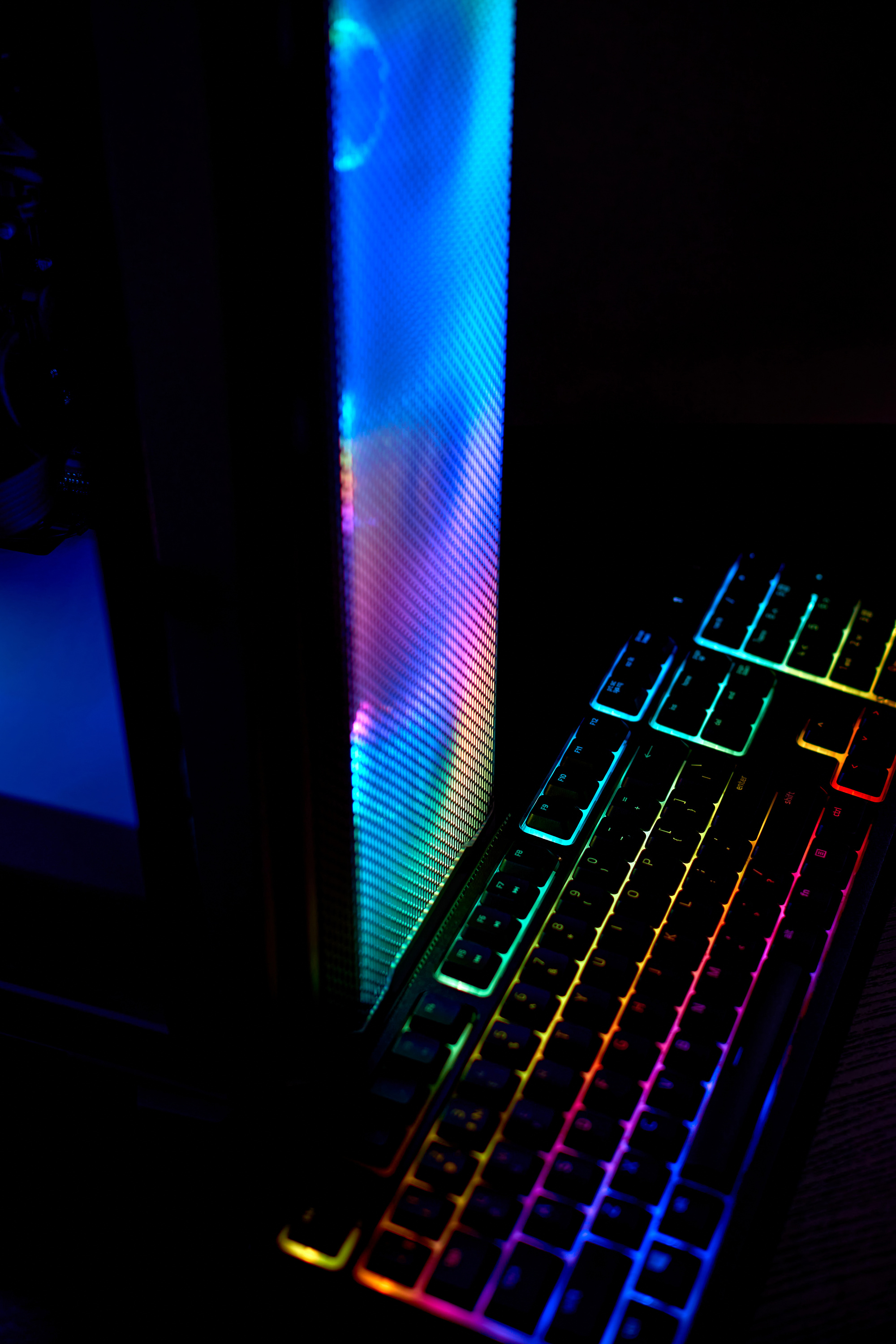 Desktop gaming PC coolers with RGB LED light. Coolers and gaming PC keyboard with colorful neon light. PC fans and keyboard with RGB backlight